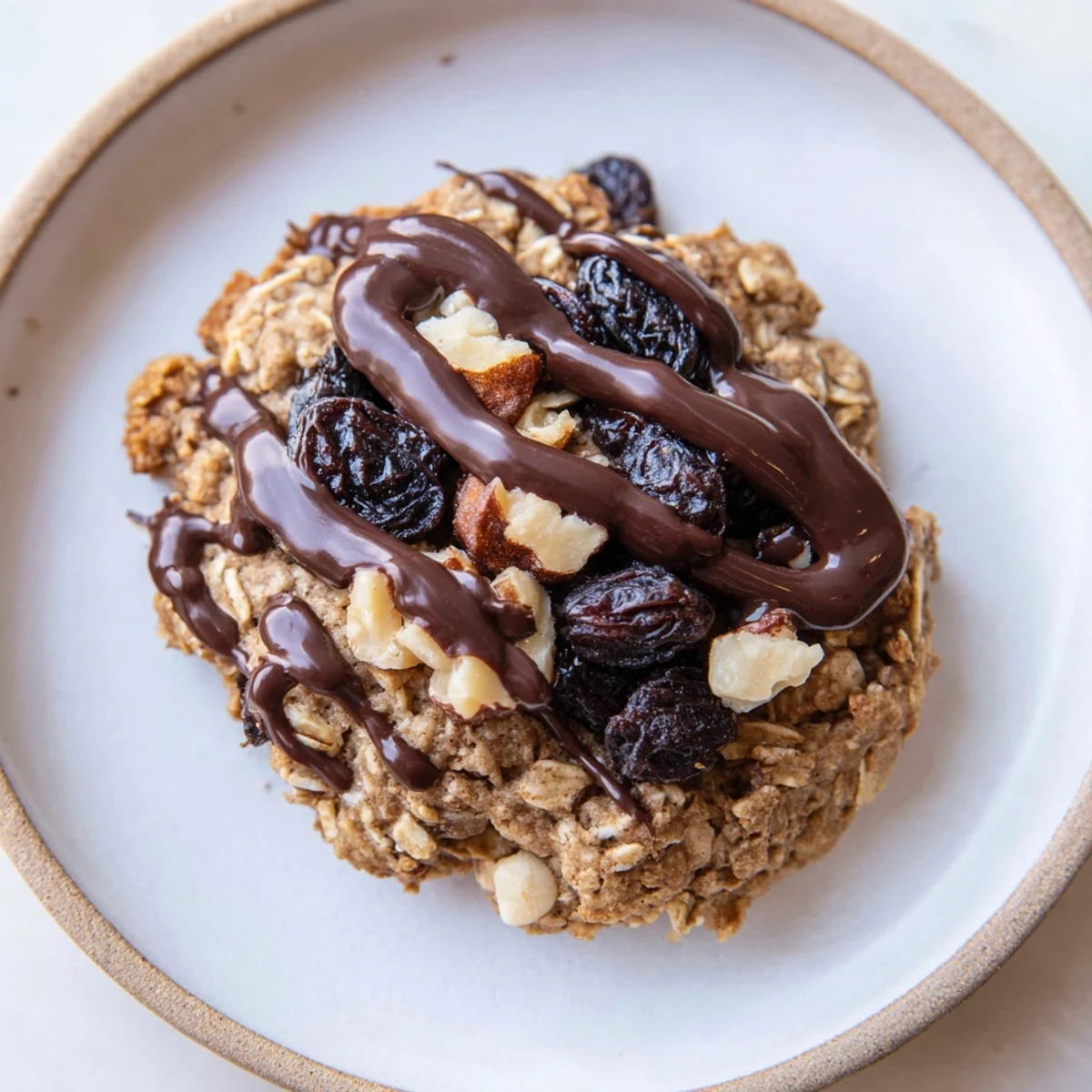 Warm oatmeal raisin cookies with a smooth frosting and drizzled hazelnut, a Frosted Delight.