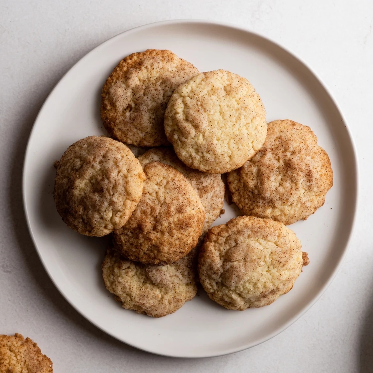 A plateful of fluffy Holiday Glow Cinnamon Drift Keto Cookies, with a dusting of cinnamon, ideal alongside coffee.