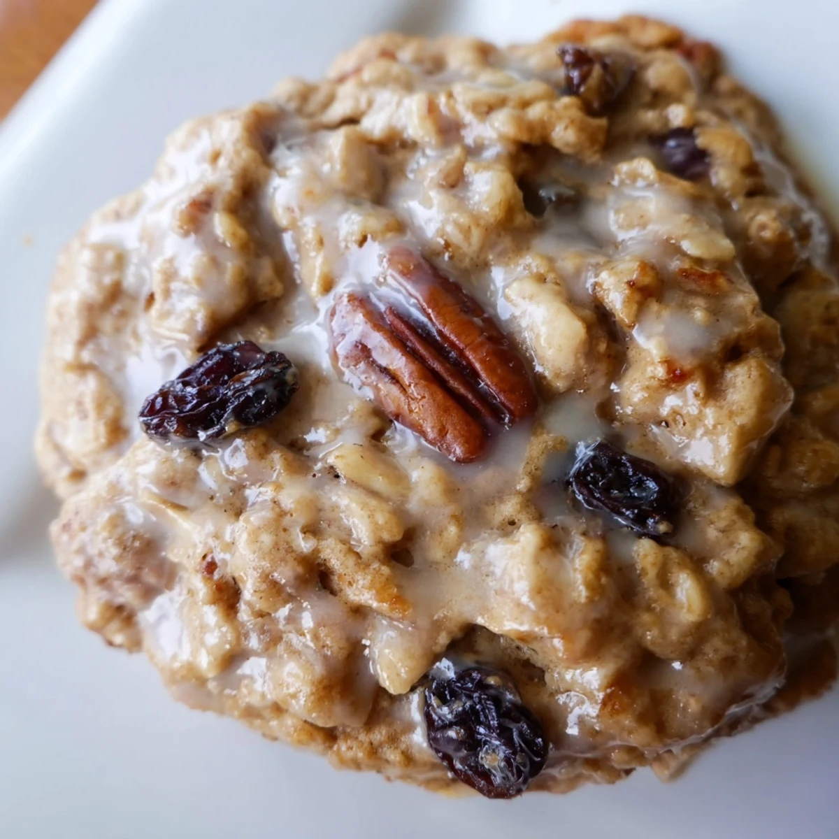 A close-up of a soft Fireplace Treat Maple Dream Oatmeal Raisin cookie broken open to reveal raisins.