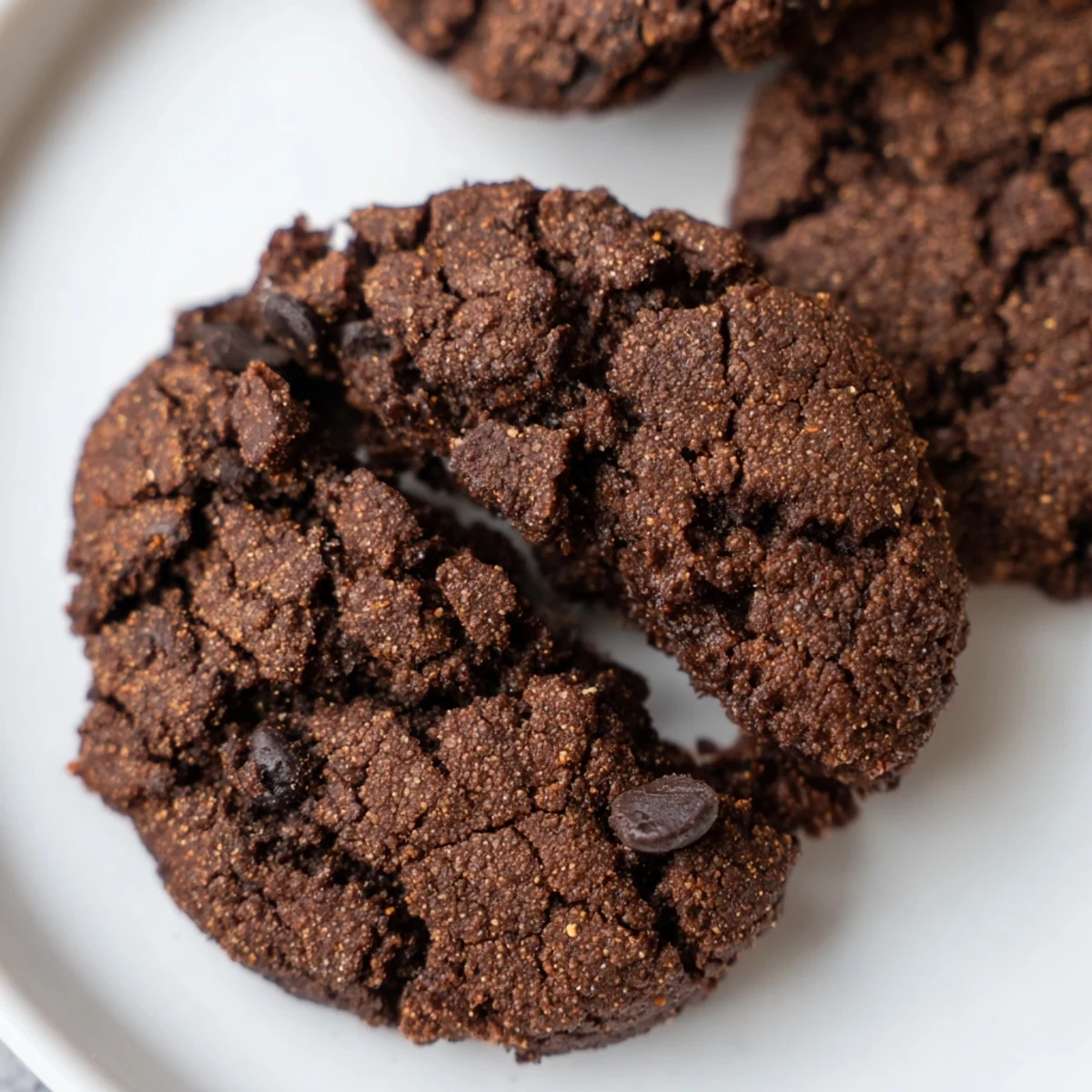 Freshly baked Winter Spice Cocoa Burst Vegan Cookies on a wire rack, showcasing chewy edges and melted vegan dark chocolate chips.