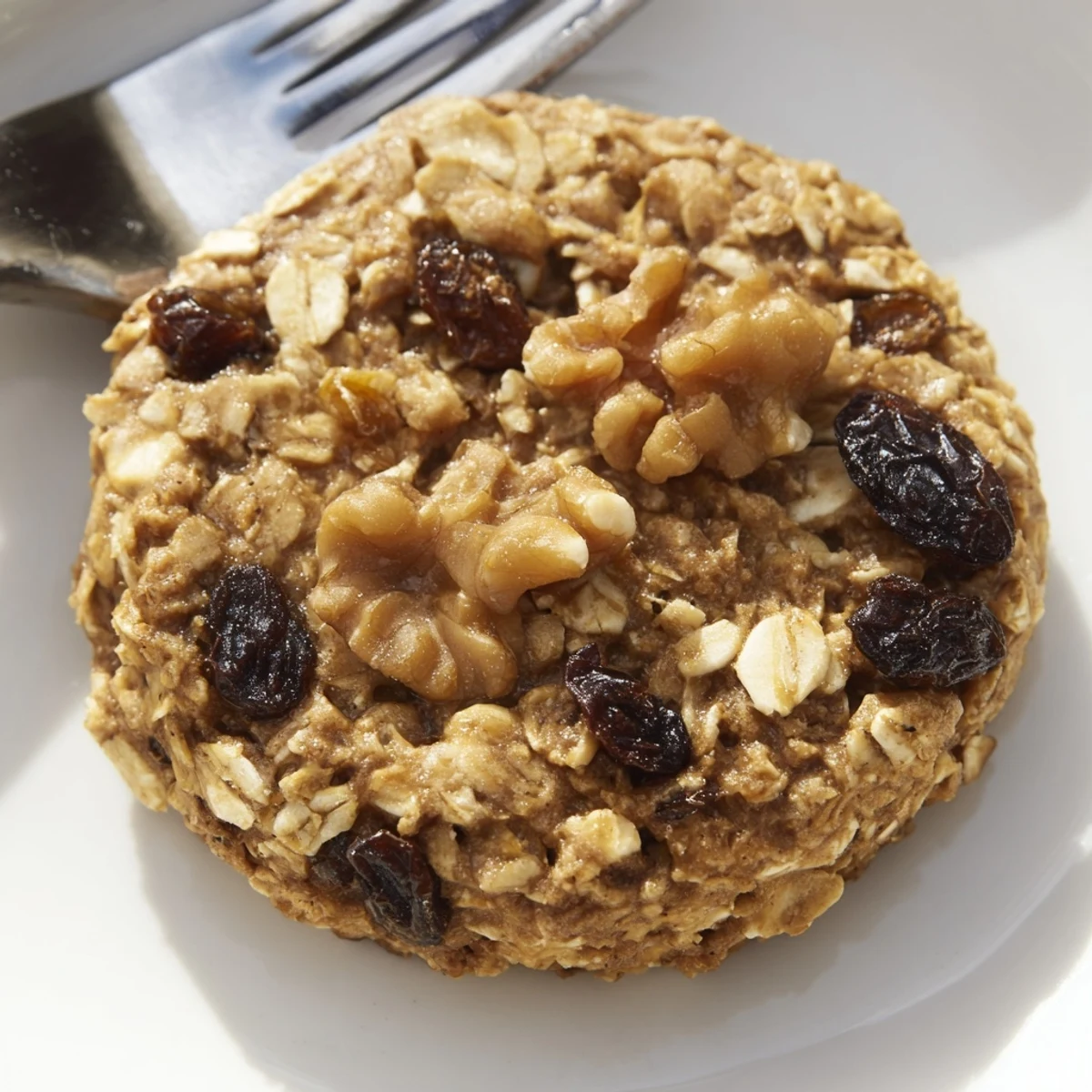 Freshly baked January Bliss Maple Dream Oatmeal Raisin cookies cooling on a wire rack with golden edges.