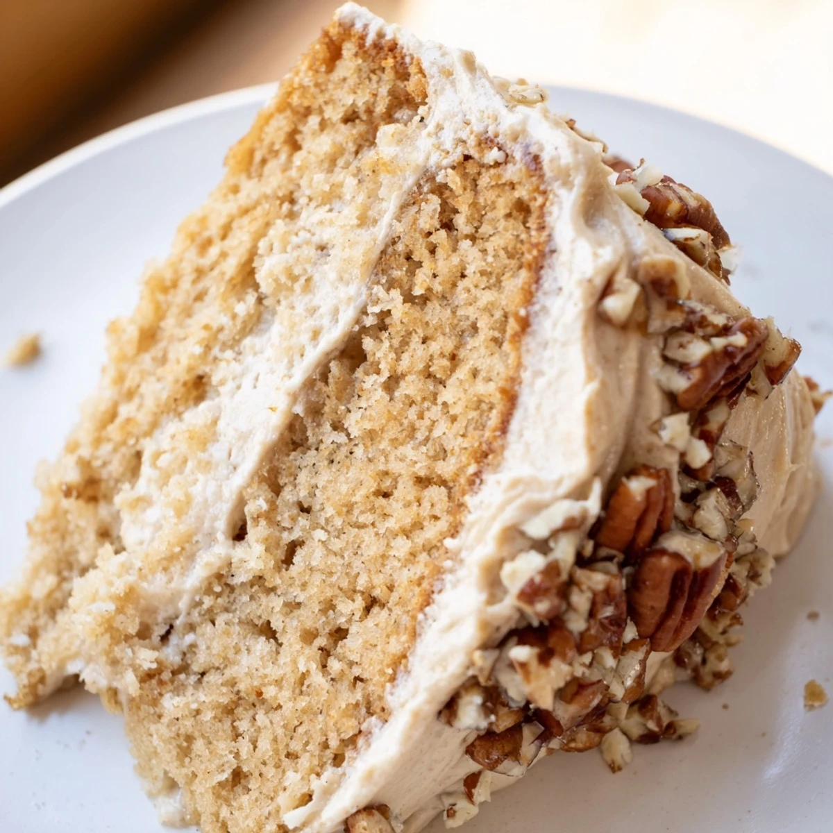 Freshly baked Frosted Delight Maple Dream sits on a cooling rack, garnished with toasted pecans and a maple sugar drizzle.