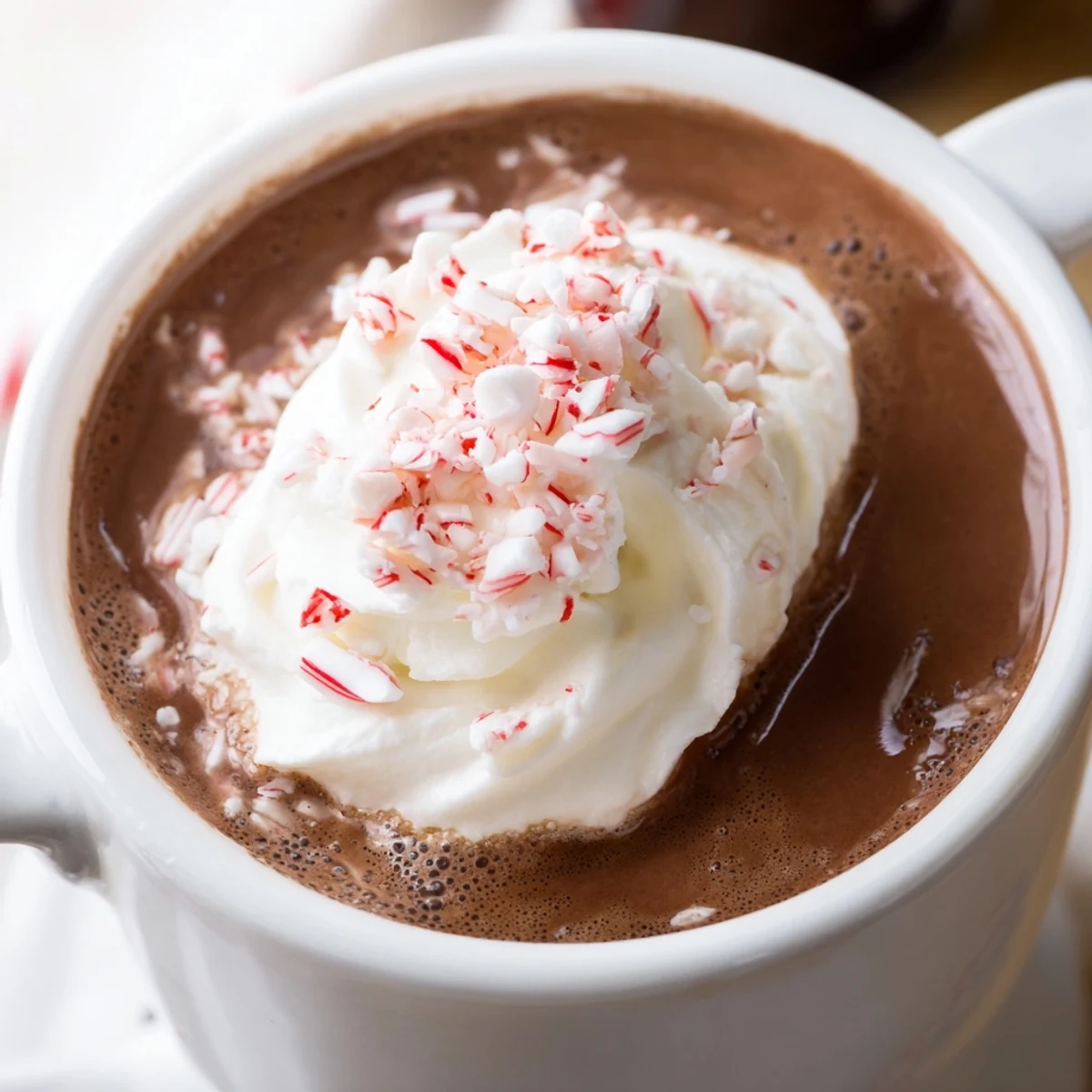 Rich Cozy Evening Peppermint Twist hot chocolate with fluffy whipped cream and peppermint sprinkles, served on a cold evening.