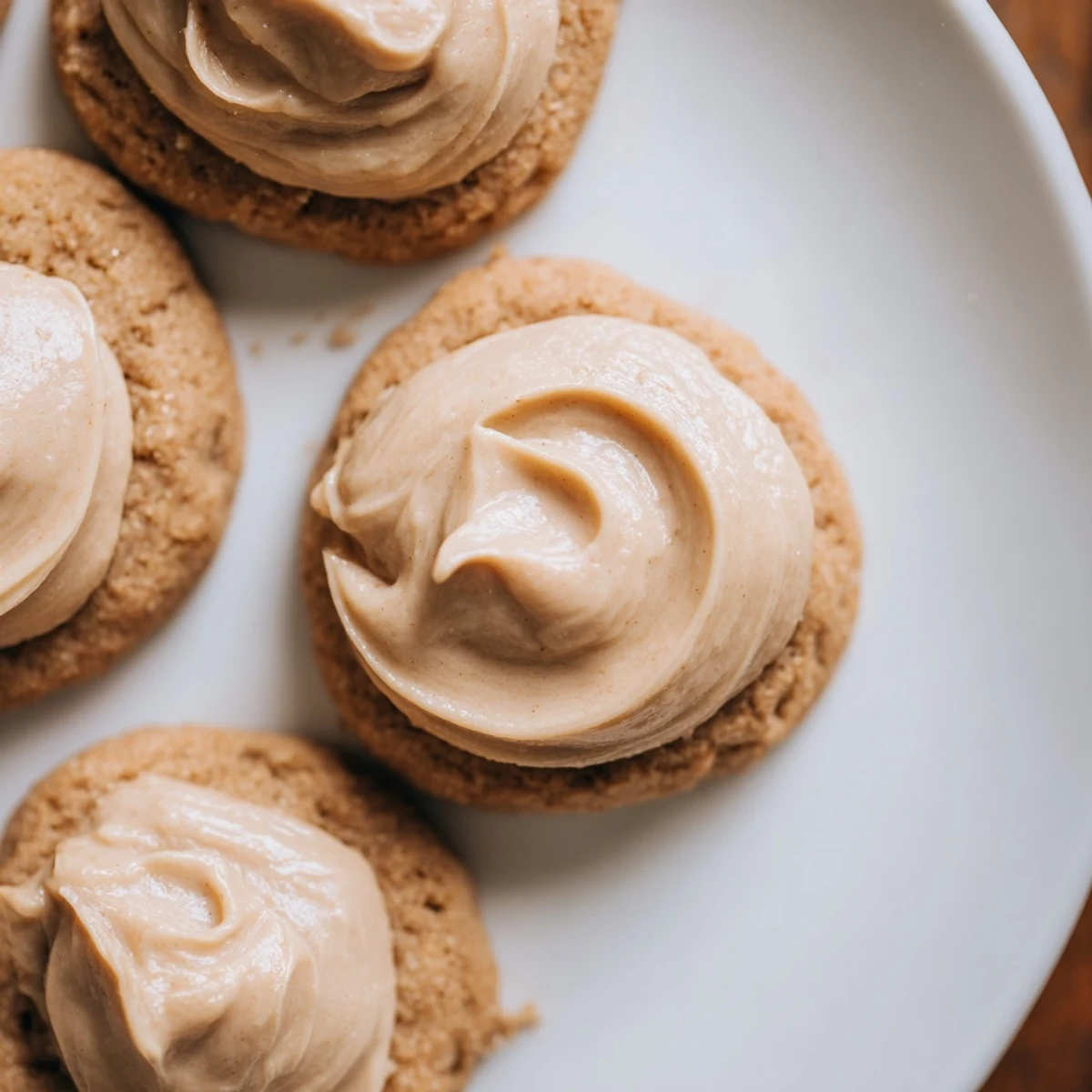 Freshly baked Holiday Glow Caramel Frost Vegan Cookies cooling on a wire rack with visible cinnamon specks and golden edges.