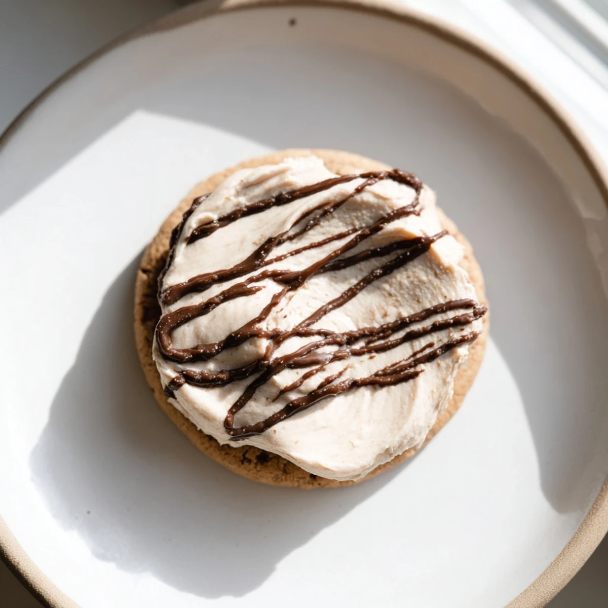 Plate of Frosted Delight Hazelnut Drizzle Keto Cookies served with a glass of cold almond milk for a perfect keto treat.