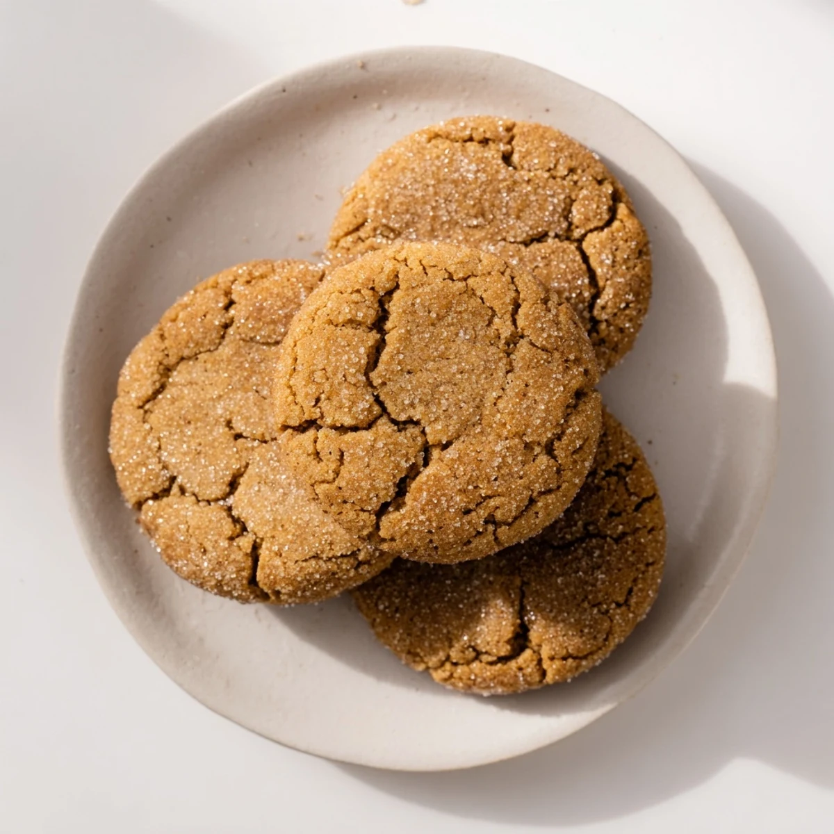Freshly baked Snowy Day Ginger Spice Vegan Cookies arranged on parchment paper, dusted with sugar and spices.