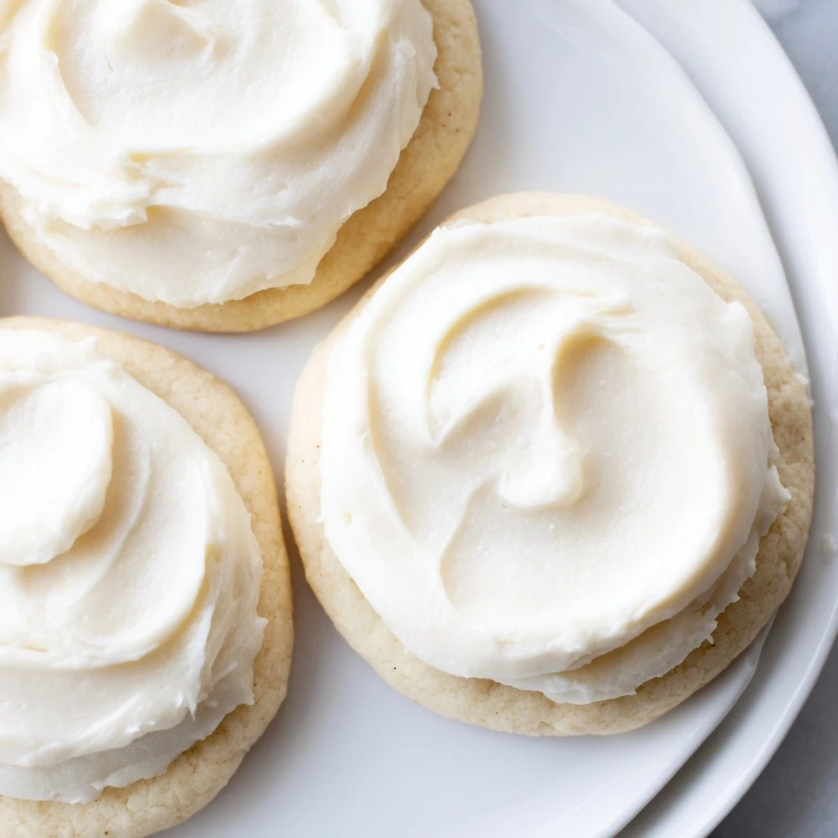 Freshly baked Frosted Delight Vanilla Cloud Keto Cookies sit on a cooling rack with a light golden edge.