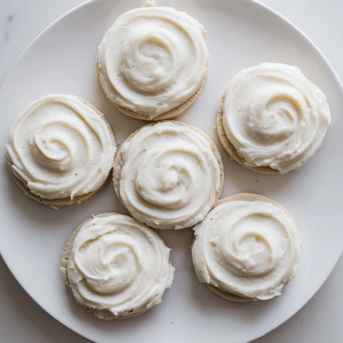 Close-up of a Frosted Delight Vanilla Cloud Keto Cookie showing a soft, airy interior and smooth vanilla frosting.