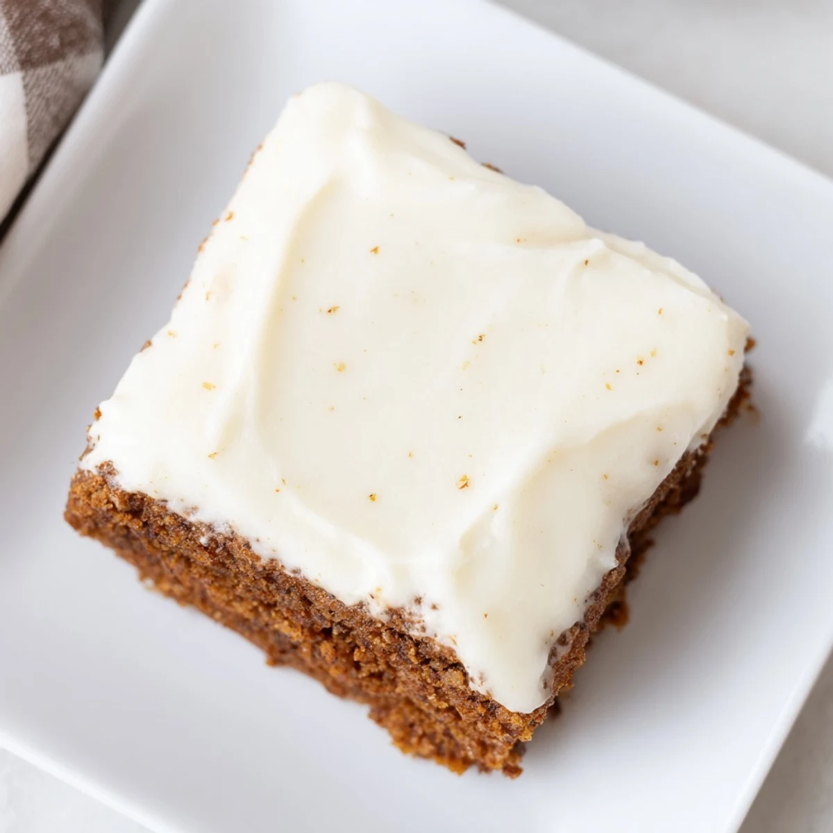 Freshly baked Frosted Delight Ginger Spice square cake, golden-brown and ready for a festive dessert gathering.