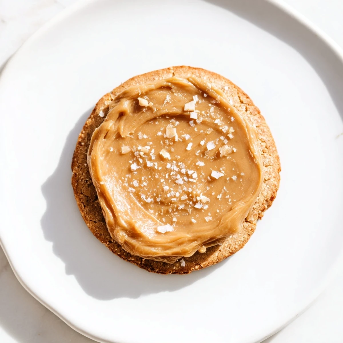 Perfectly baked Cozy Evening Caramel Frost Keto Cookies, lightly dusted with powdered sweetener and arranged on a wire cooling rack for a rustic presentation.  