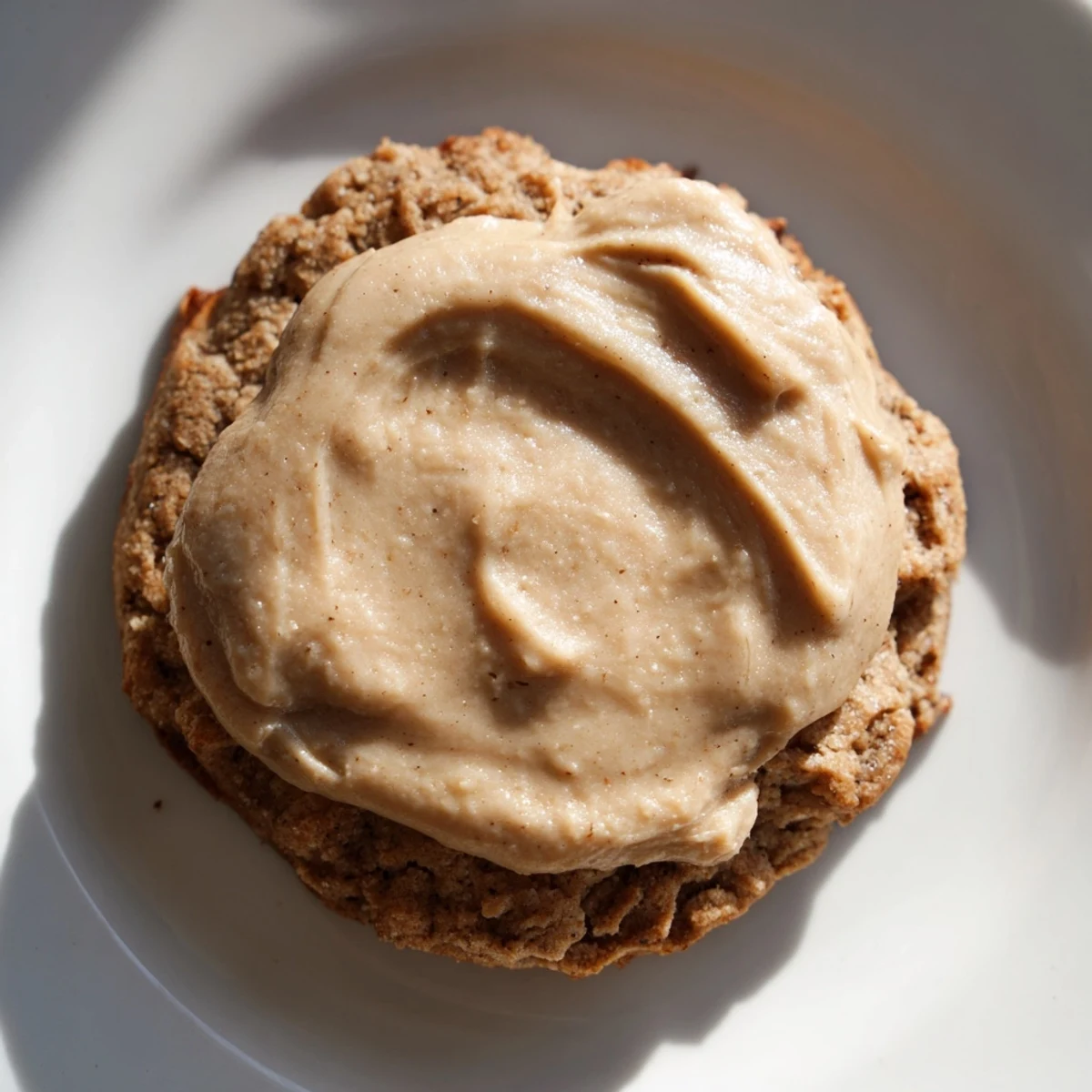 Winter Market Caramel Frost Vegan Cookies are stacked on a cooling rack, their soft, spiced surfaces glazed with a glossy, golden caramel-style frosting for a cozy treat.