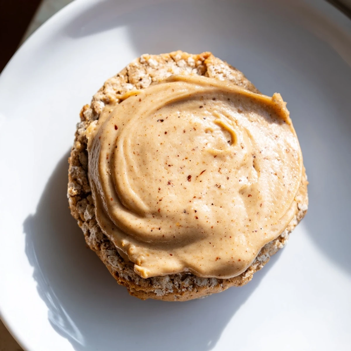 Set against a rustic backdrop, Winter Market Caramel Frost Vegan Cookies are plated beside a steaming mug, evoking a perfect, comforting winter dessert pairing.