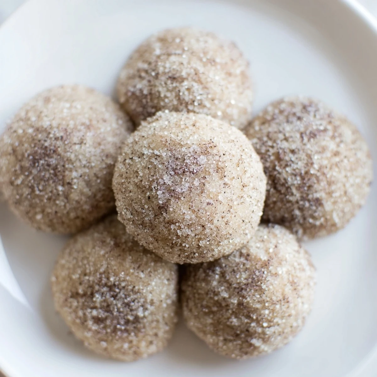 A close-up of Winter Warmth Mocha Whisper Sugar Cookies arranged on a wire rack, with powdered sugar dusting and a steaming mug of coffee in the background for a cozy winter treat.