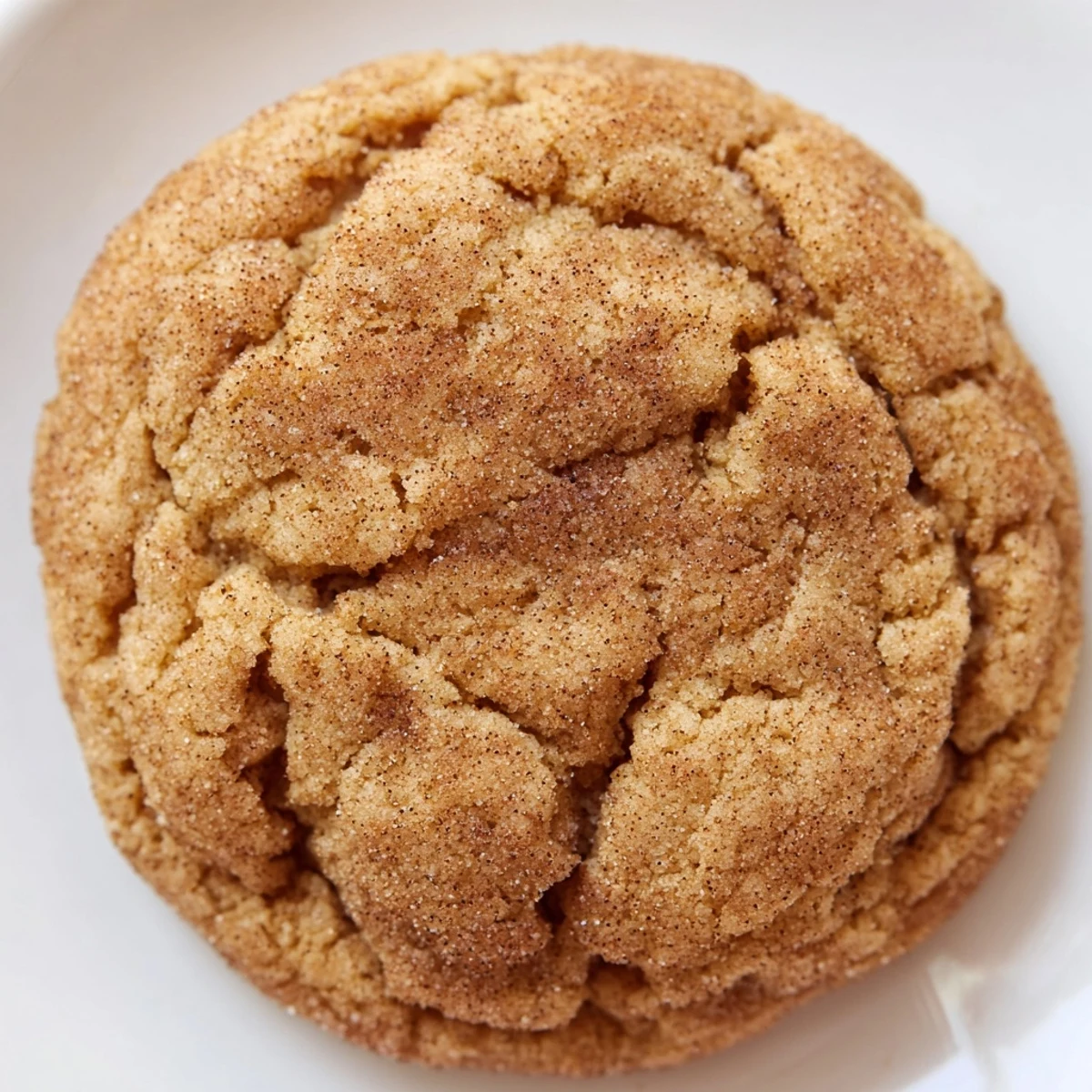 Gluten-Free Brown Butter Snickerdoodle Cookies on a rustic wooden board beside a glass of milk, highlighting their tender texture and rich brown butter flavor.