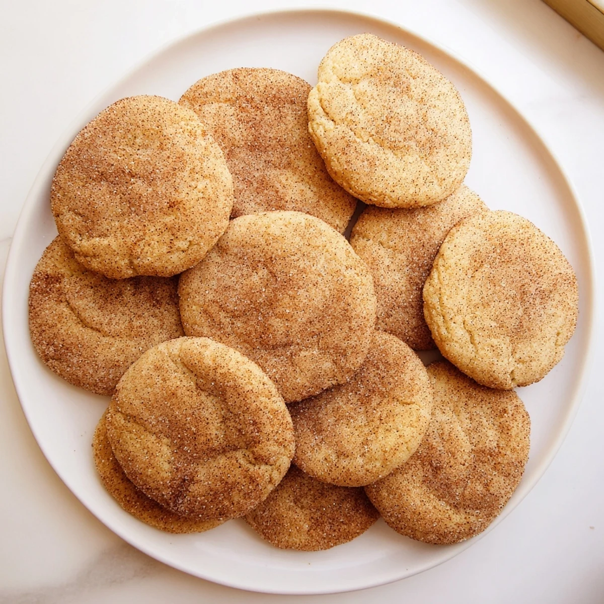 Gluten-Free Churro Sugar Cookies on a white plate, dusted with cinnamon sugar, ready to enjoy with a glass of milk.