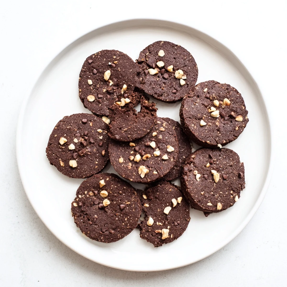 A close up of Keto Mocha Hazelnut Cookies served on a plate with a glass of cold milk for dipping.