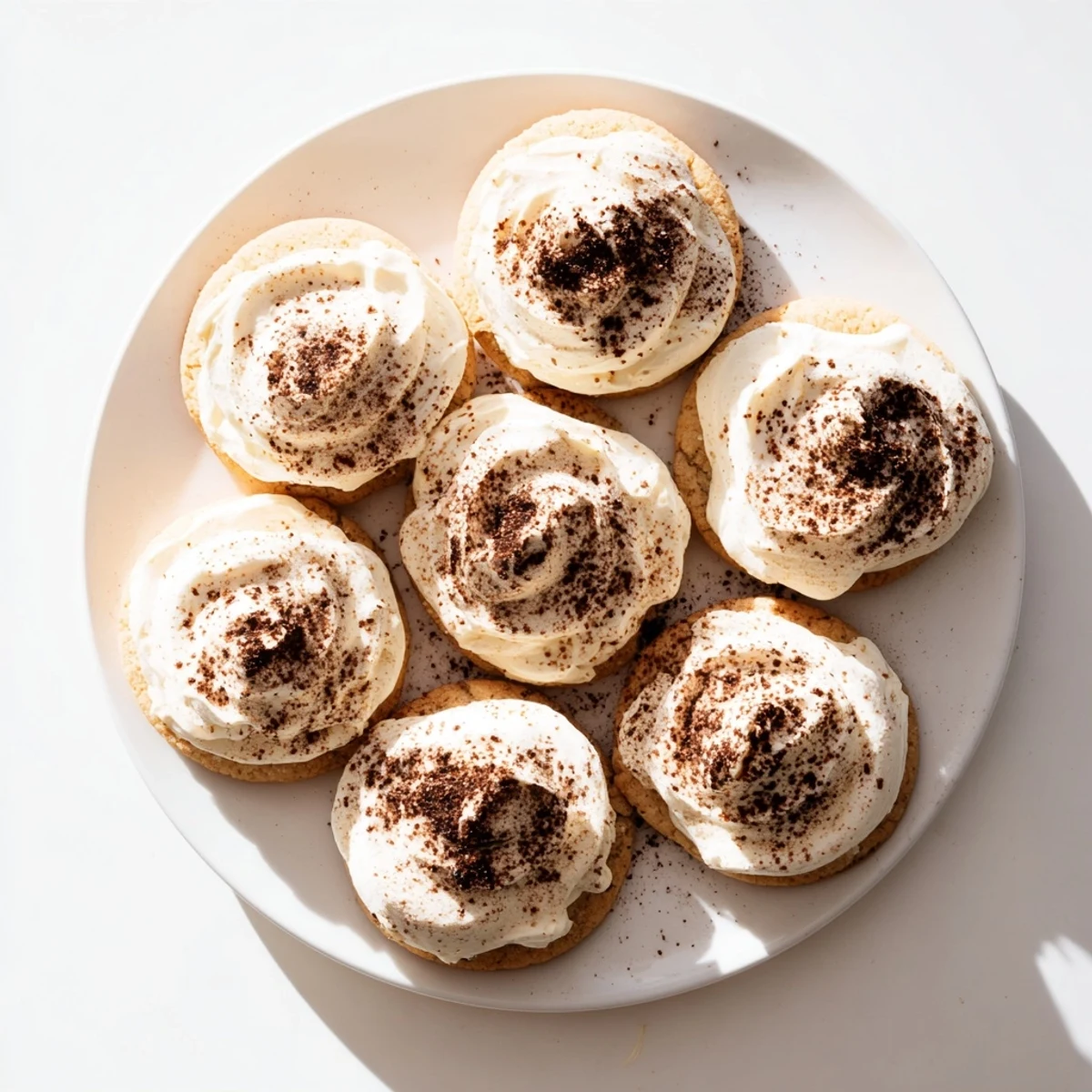 Soft tiramisu inspired sugar cookies topped with creamy mascarpone frosting and dusted with rich cocoa powder