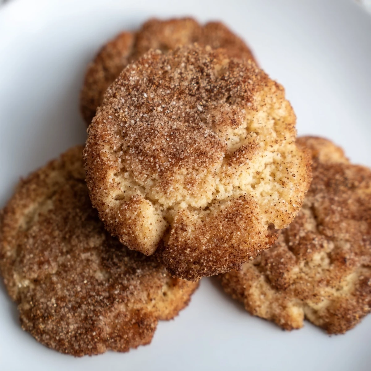 Golden brown keto cinnamon butter cookies cooling on a wire rack with a light dusting of sweet cinnamon sugar topping