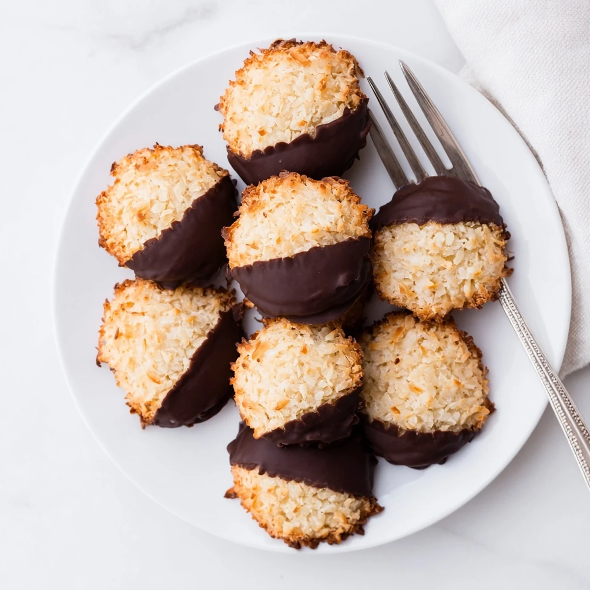 Tender coconut cookies half-dipped in rich dark chocolate, a perfect gluten-free dessert for sharing