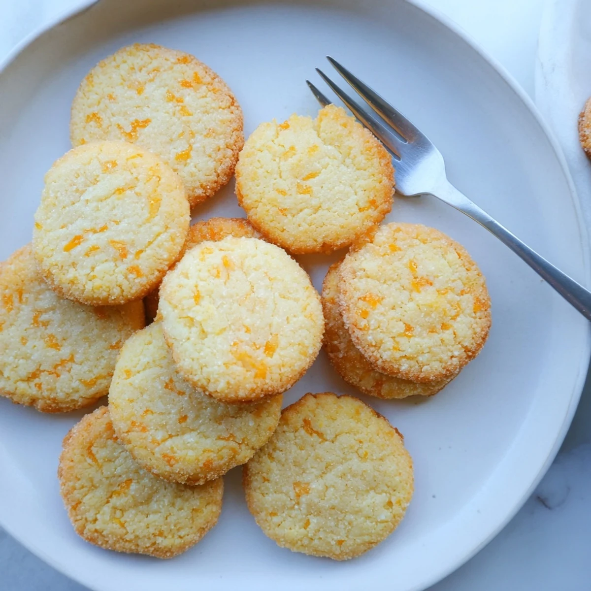 Gluten-free orange blossom sugar cookies cooling on wire rack with citrus zest garnish