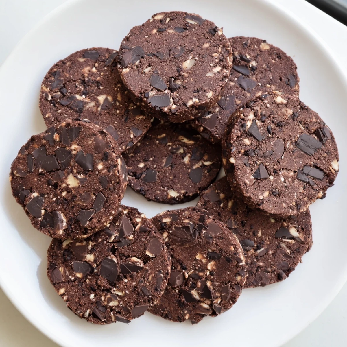 Chewy keto dark chocolate coconut cookies studded with melty chocolate chunks on a parchment-lined baking sheet
