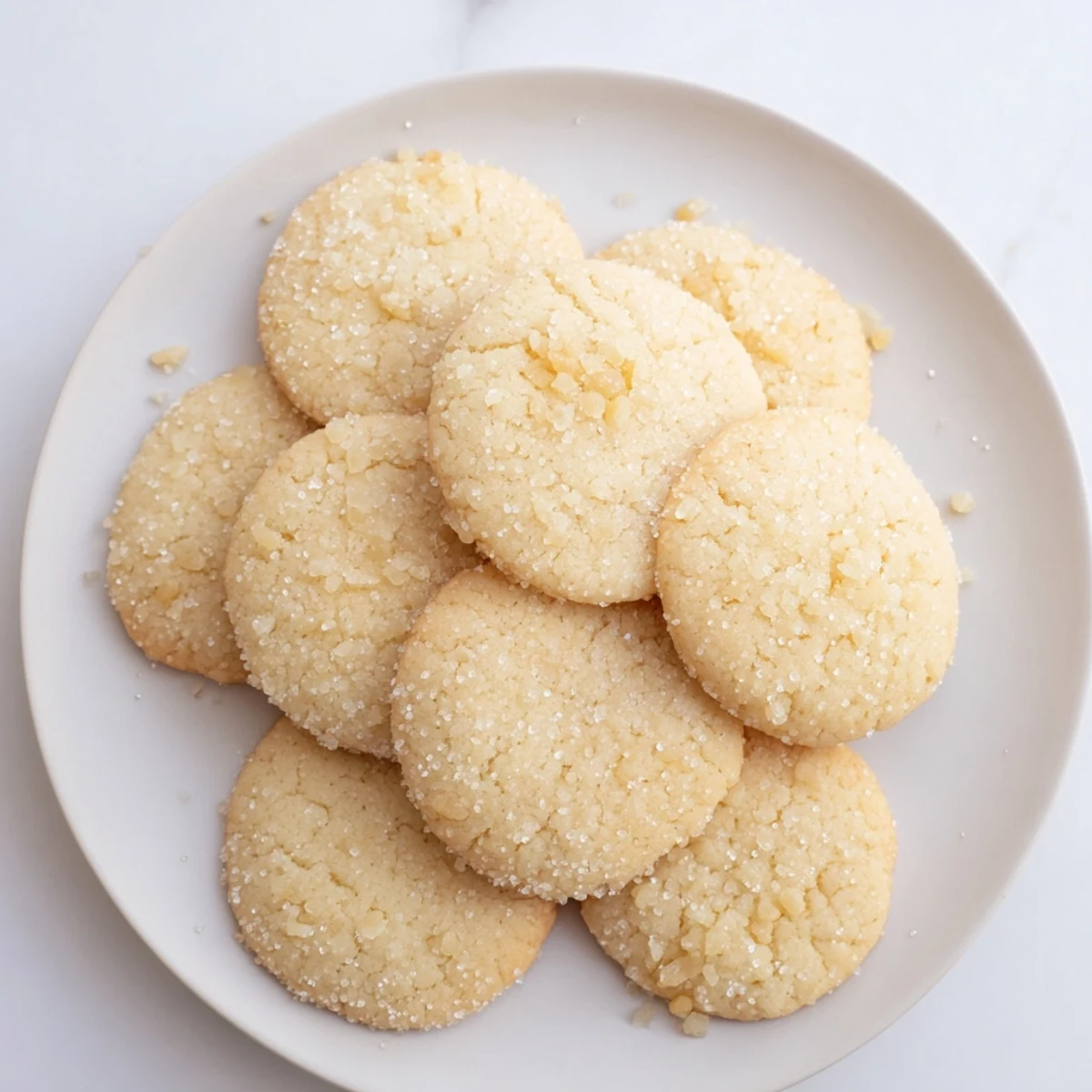 Batch of crinkled vegan pineapple ginger sugar cookies rolled in sparkling sugar ready for serving