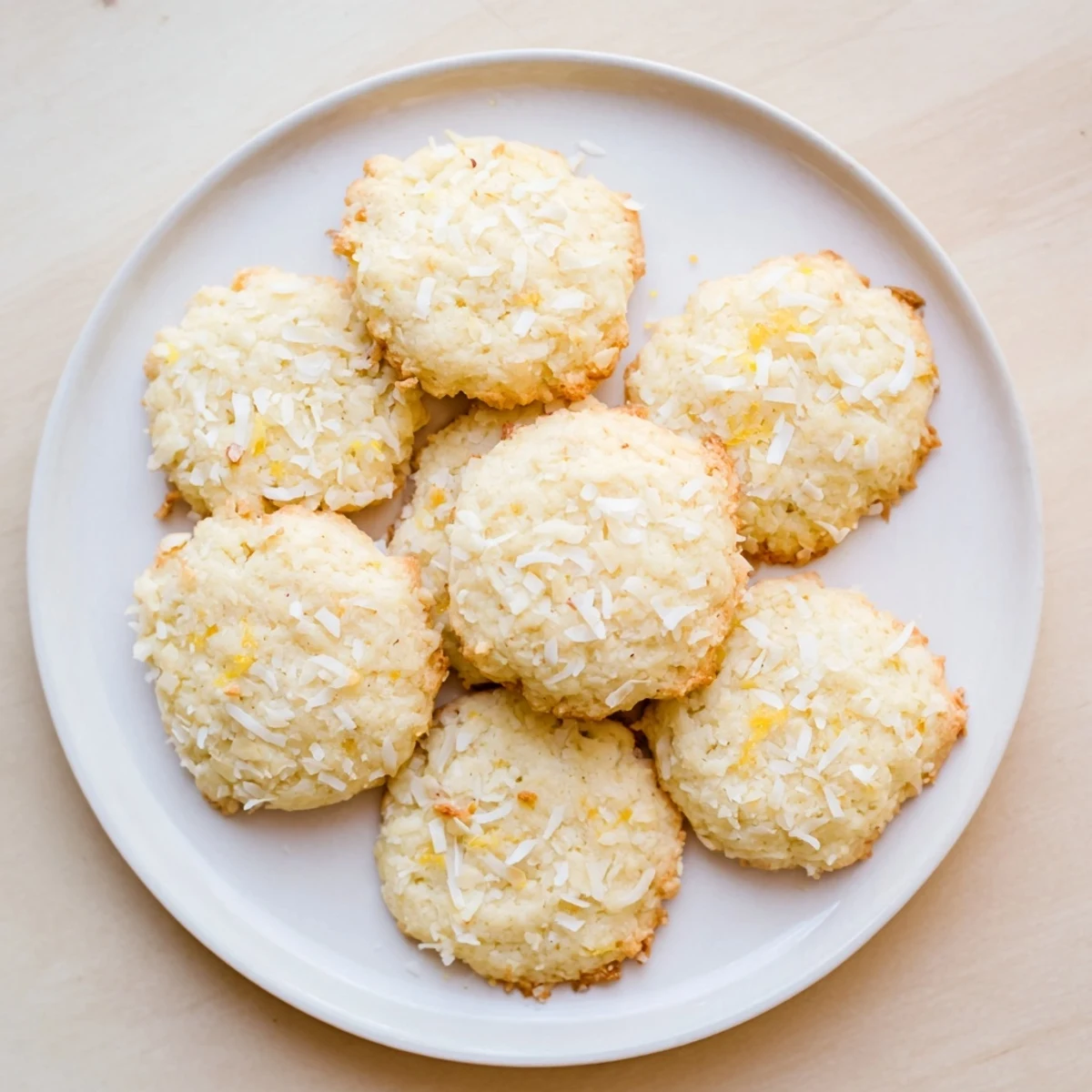 Close-up of gluten-free lemon coconut cookies showing golden edges and bright lemon zest