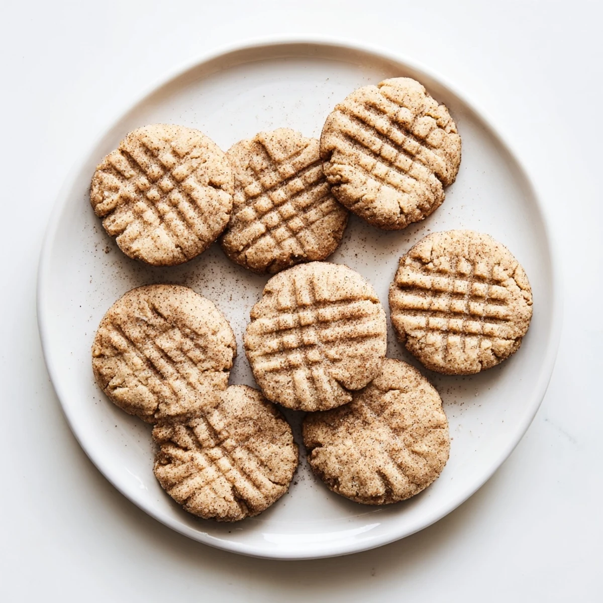 Golden keto cinnamon almond butter cookies cooling on a wire rack with fork crisscross pattern