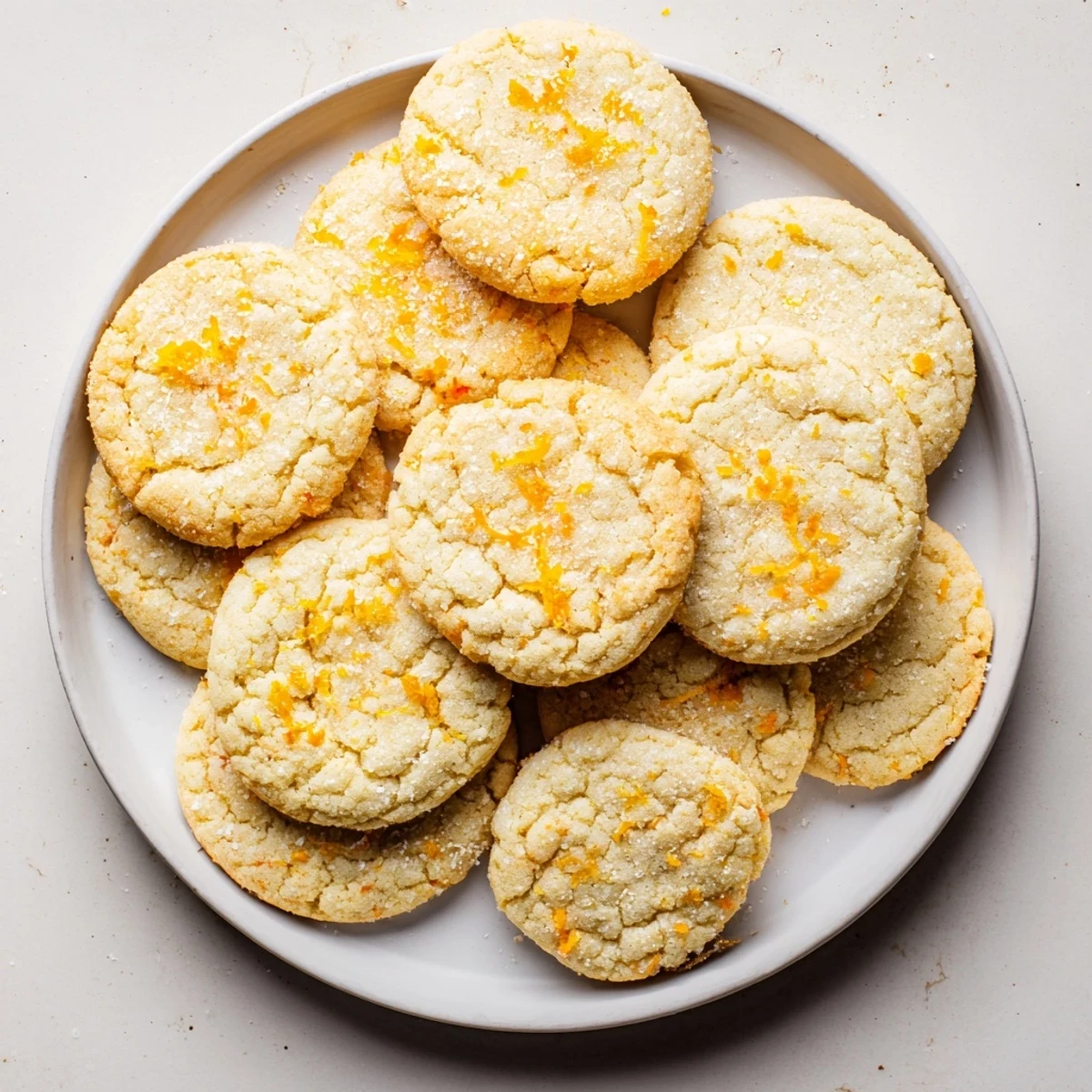 Soft vegan tangerine vanilla sugar cookies with golden edges and sparkling sugar coating