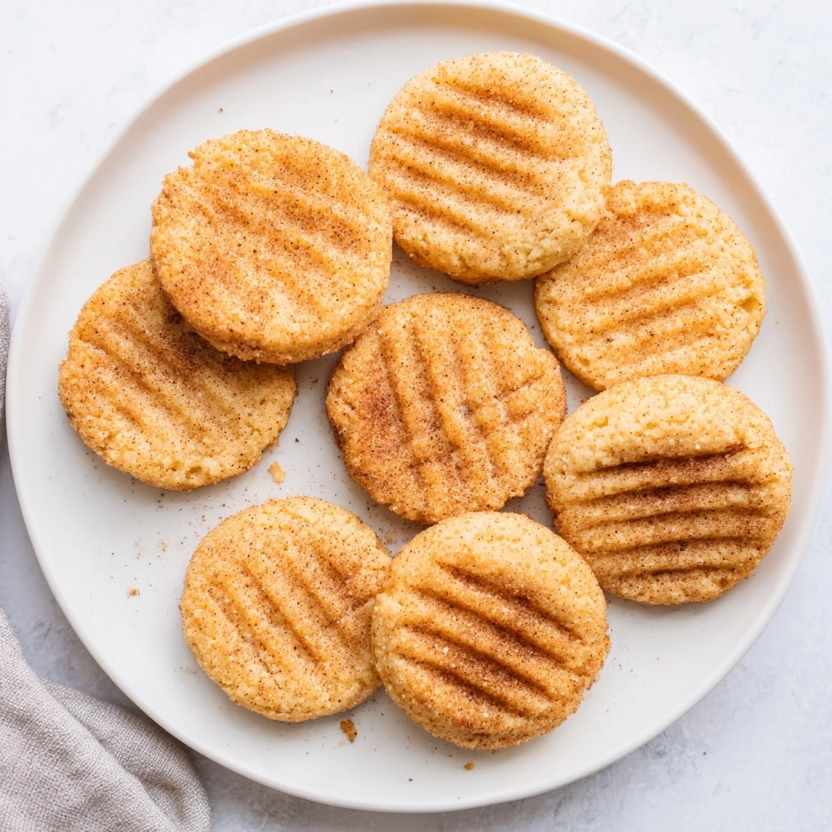 Stack of homemade keto cinnamon vanilla butter cookies on a white plate