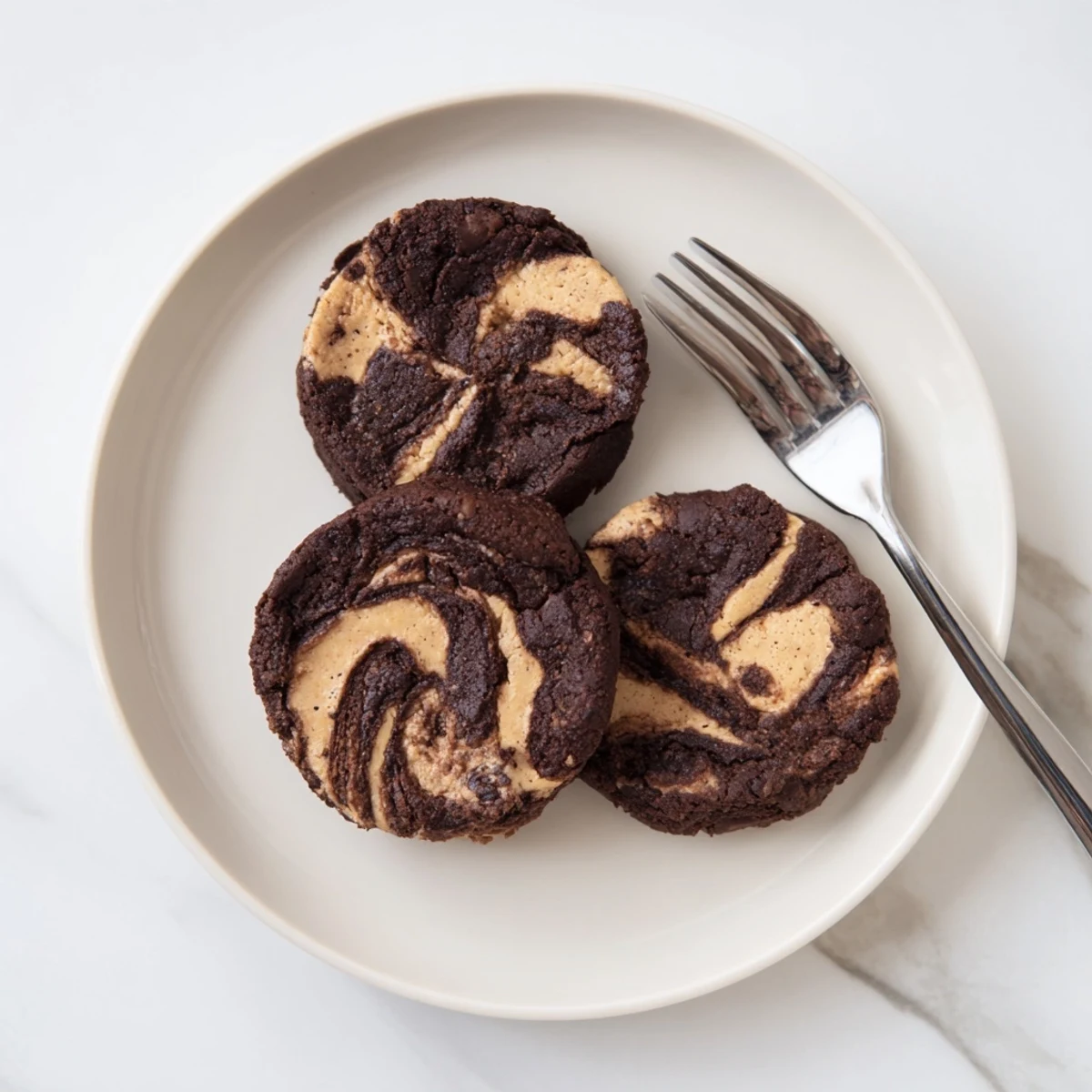 Fudgy keto chocolate almond butter swirl cookies with marbled topping on rustic parchment paper