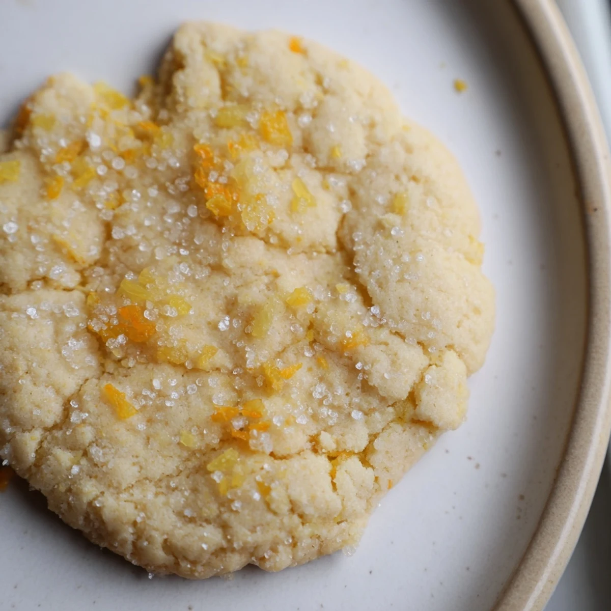 Bright chewy vegan pineapple orange sugar cookies arranged on a rustic white serving plate