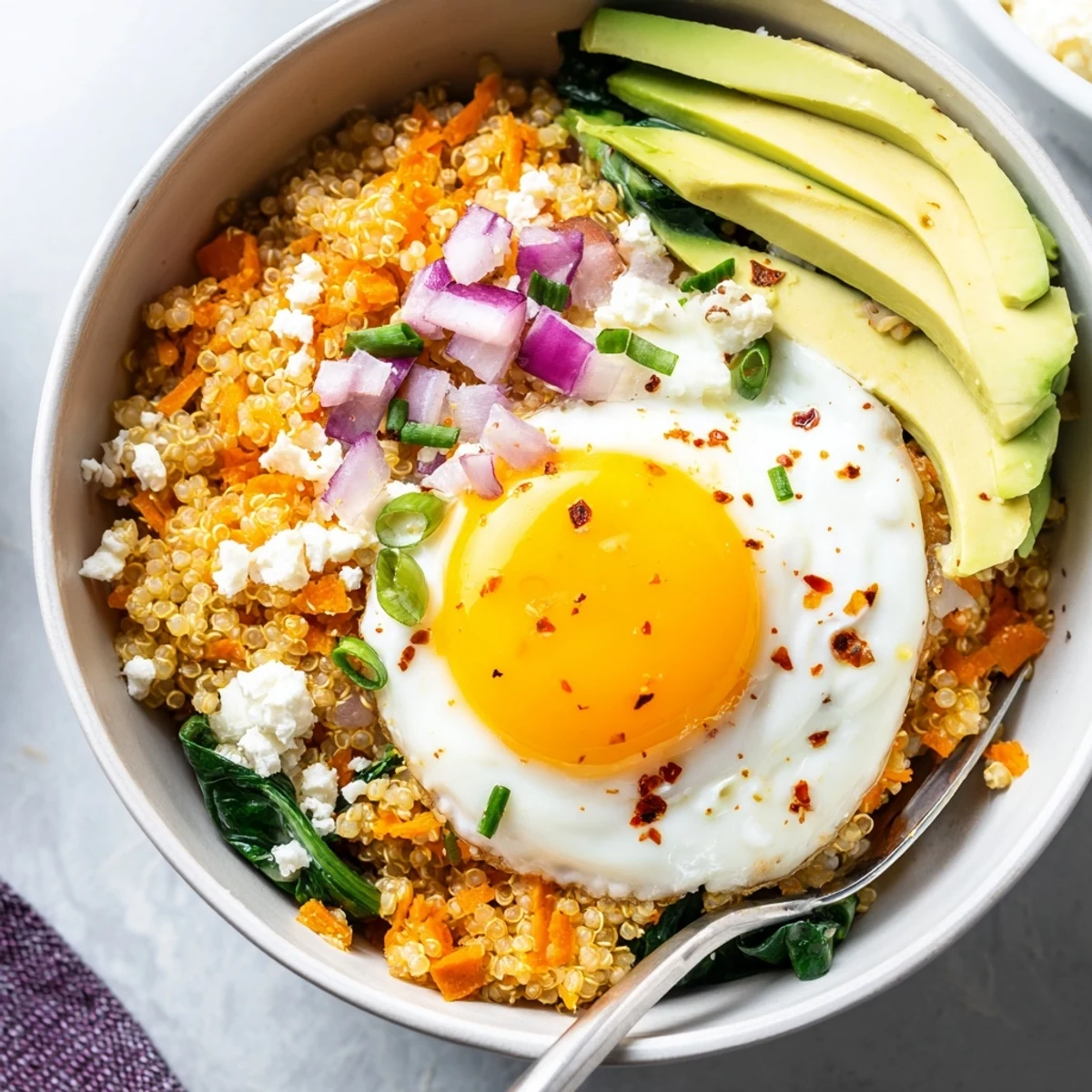Steamy Savory Carrot and Spinach Quinoa Breakfast Bowl garnished with fresh chives
