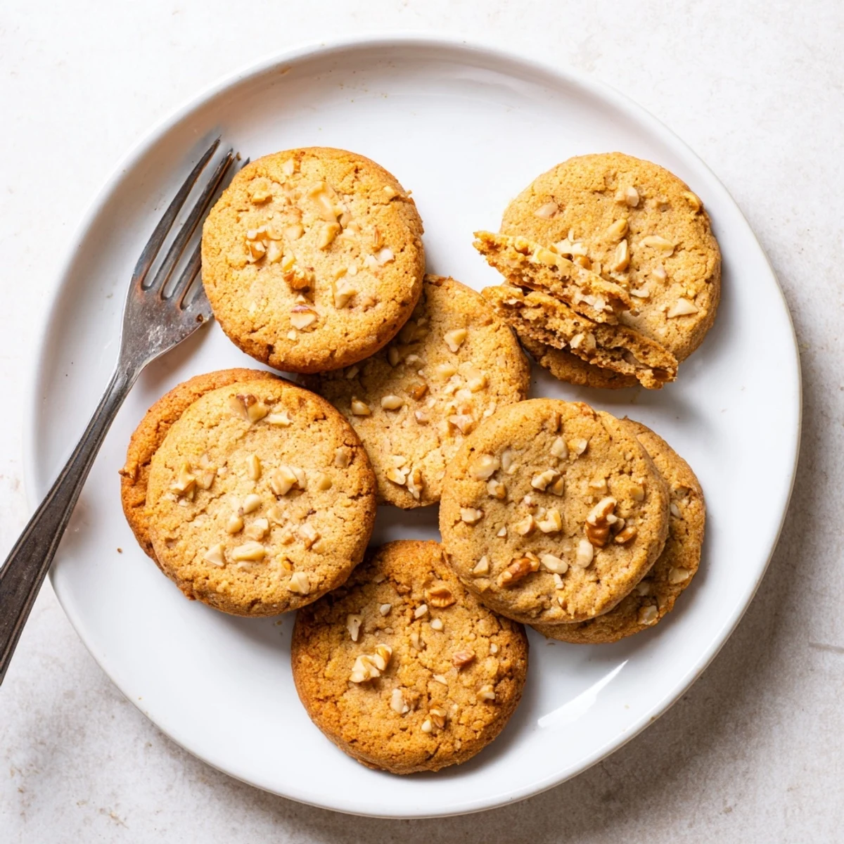 Stack of buttery keto vanilla walnut cookies topped with extra walnut pieces ready for gluten-free dessert serving