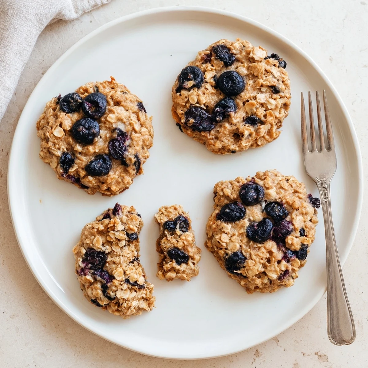 Soft, chewy Vegan Blueberry Pear Oatmeal Raisin Cookies plated with almond milk.