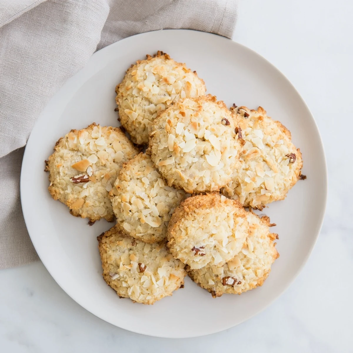 Chewy sugar-free maple coconut crunch cookies drizzled with glaze on rustic wooden surface