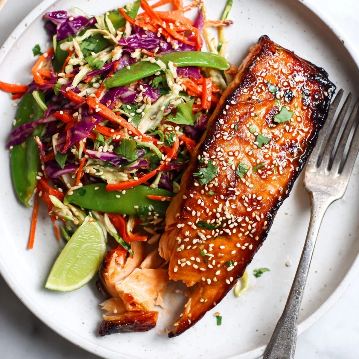 Seared Miso Ginger Salmon With Sesame Snap Pea Slaw on parchment, ready to serve