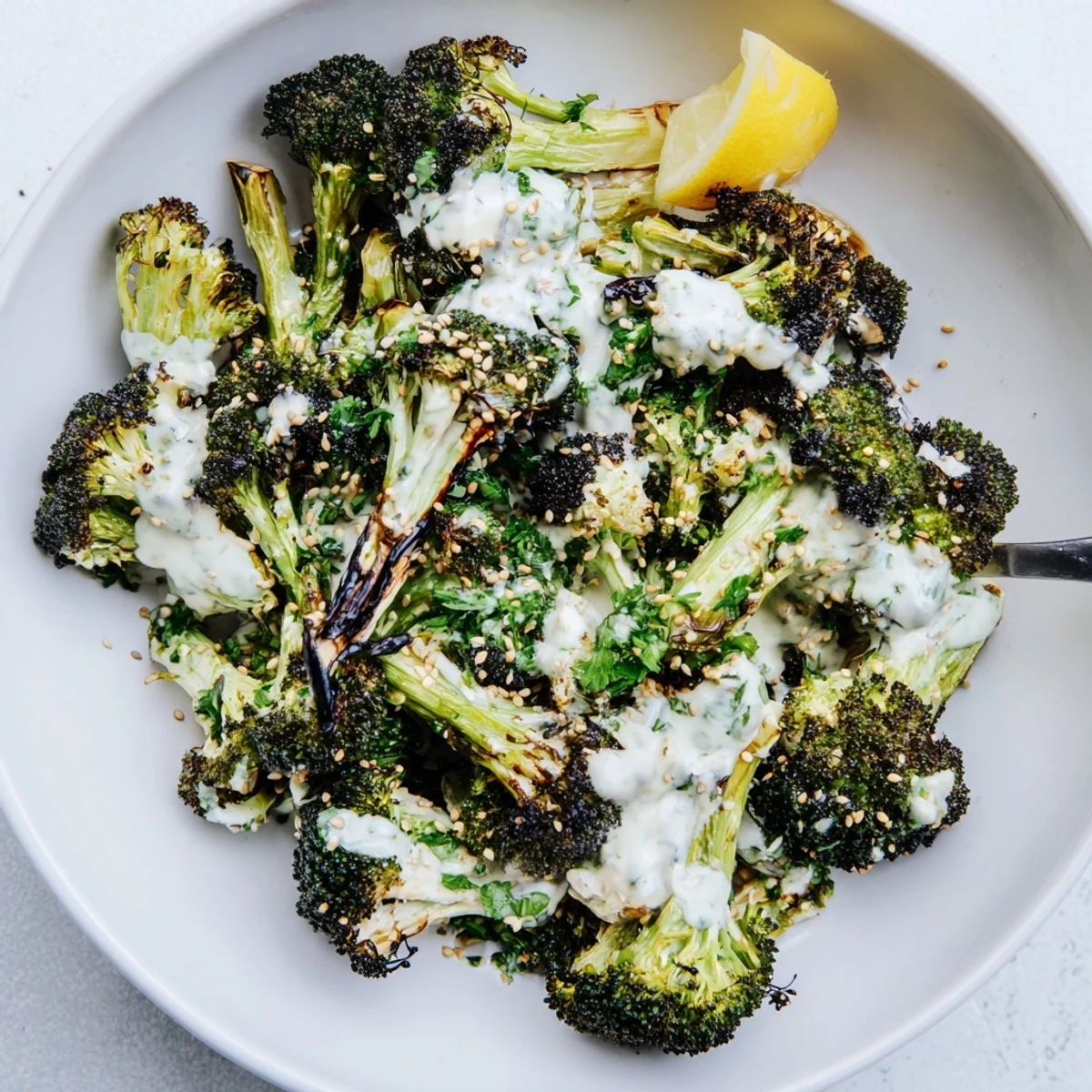 Roasted Broccoli With Lemon Herb Tahini Sauce glistening, charred edges and toasted sesame.