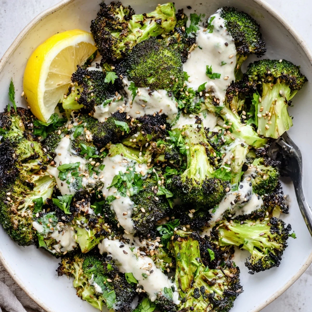 Warm platter topped with lemon wedges and Roasted Broccoli With Lemon Herb Tahini Sauce.