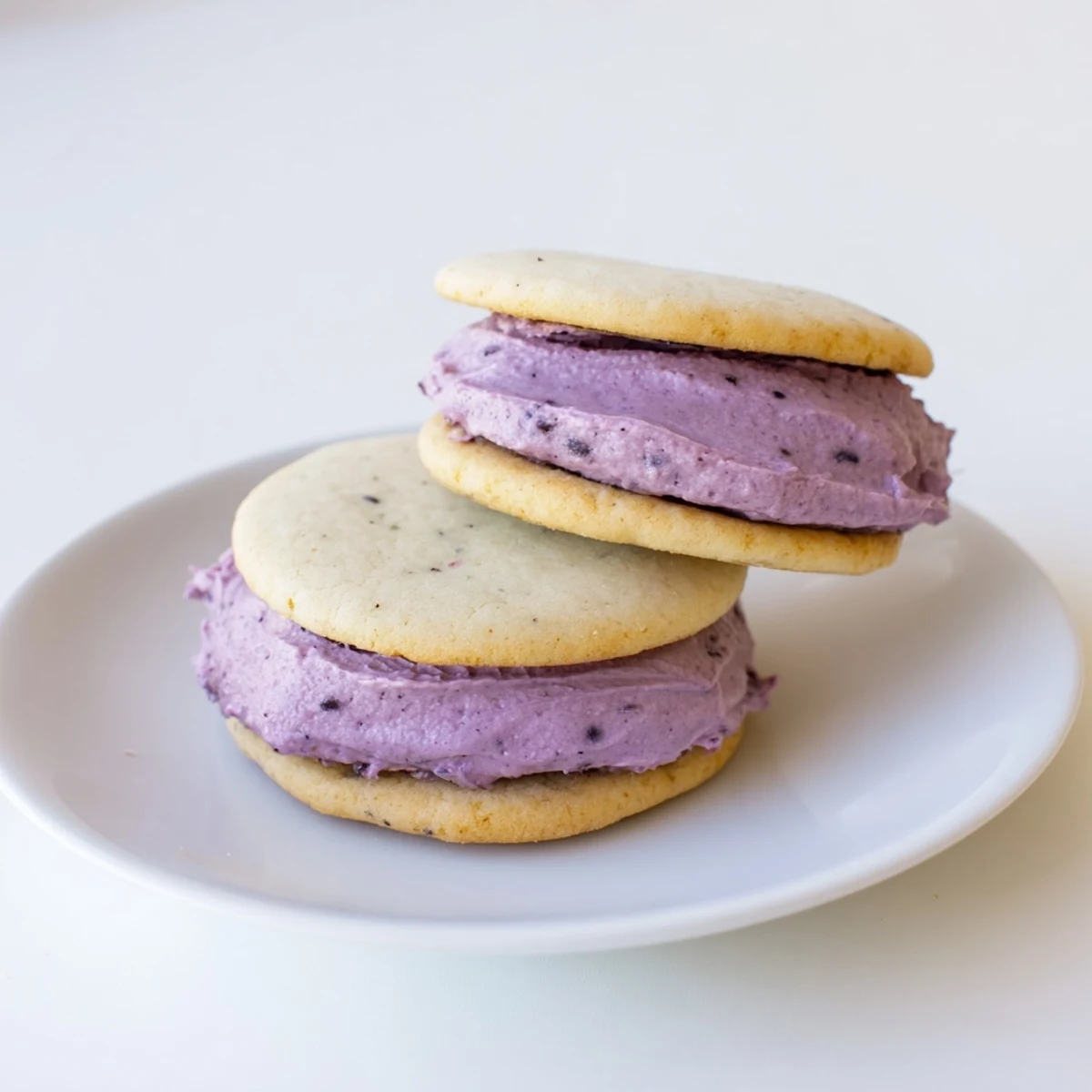 Soft vegan pineapple blackberry cream sugar cookies sandwiched with vibrant purple fruit filling