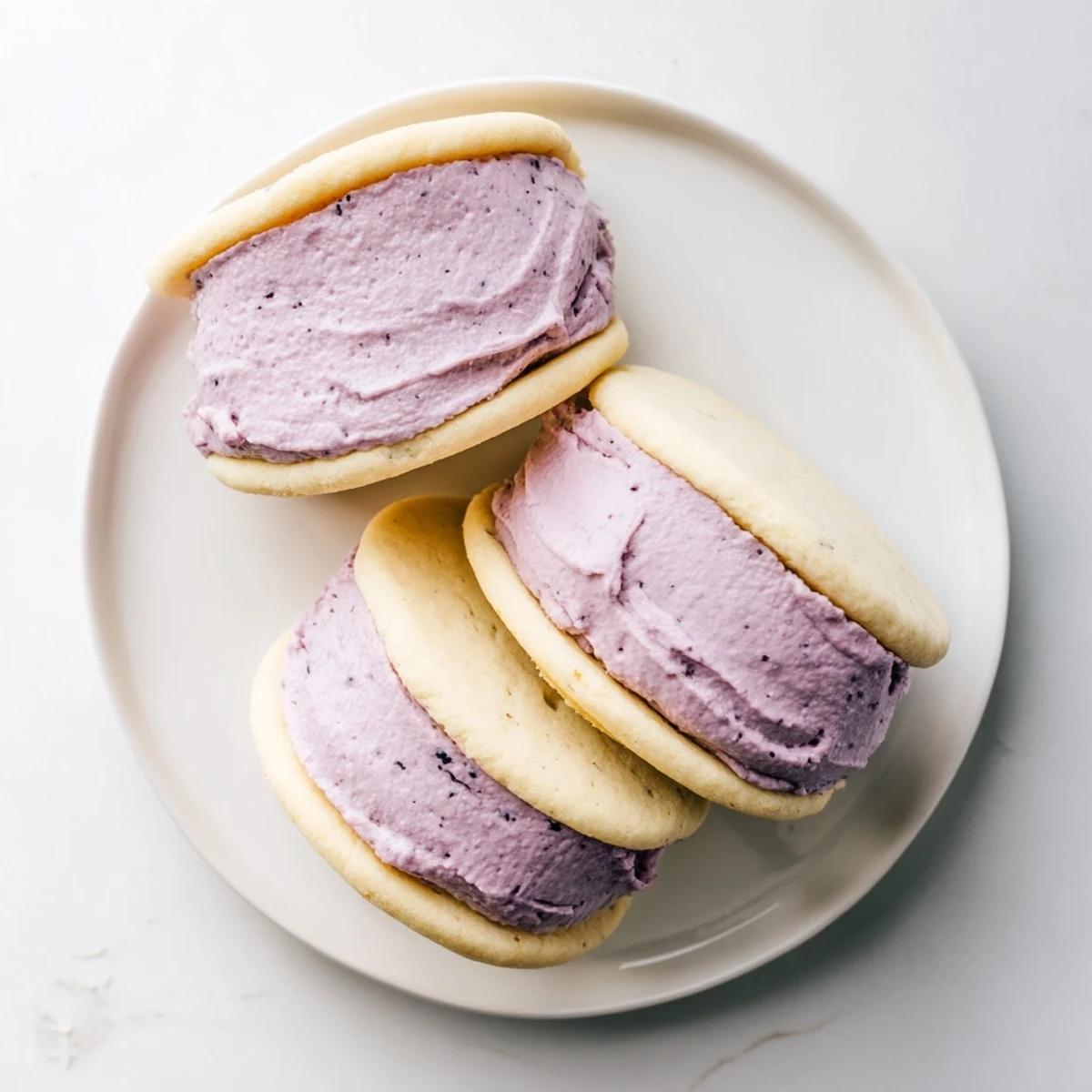 Golden vegan sugar cookies topped with tangy pineapple blackberry cream and fresh fruit garnish