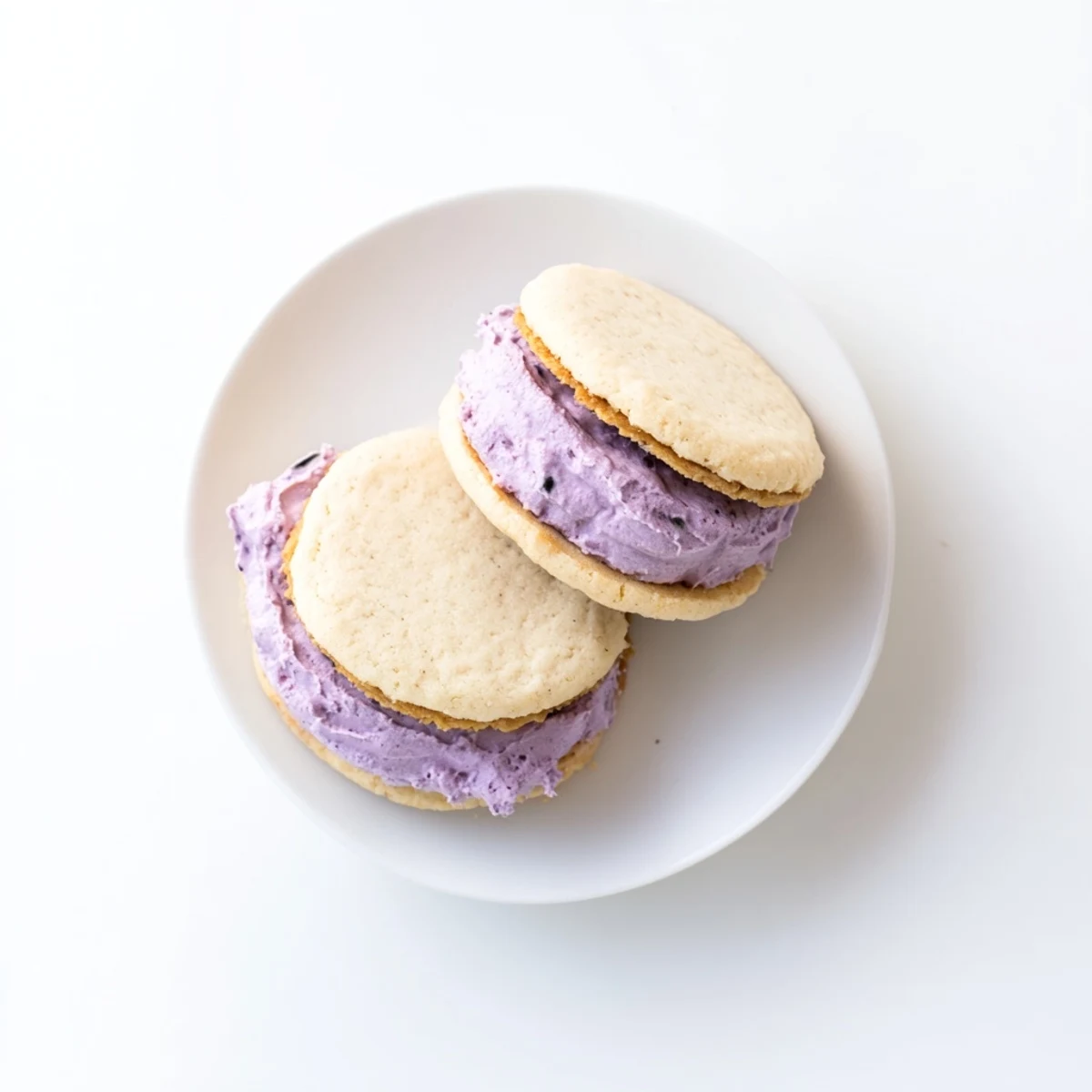 Chewy dairy-free pineapple blackberry cream sugar cookies stacked on a white serving plate