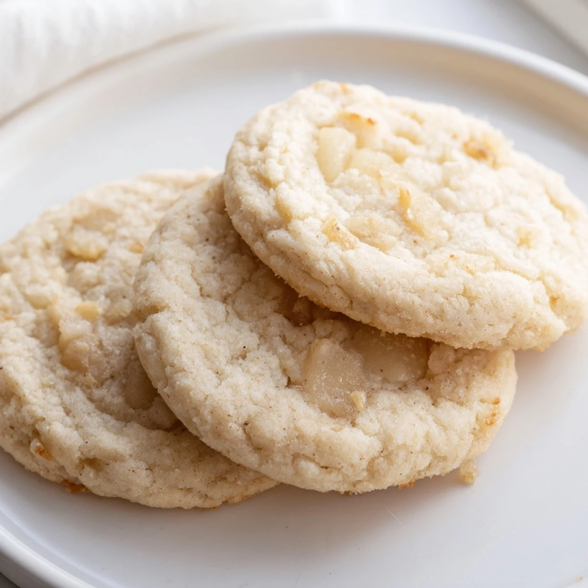 Chewy vegan vanilla pear sugar cookies studded with sweet pear pieces on parchment