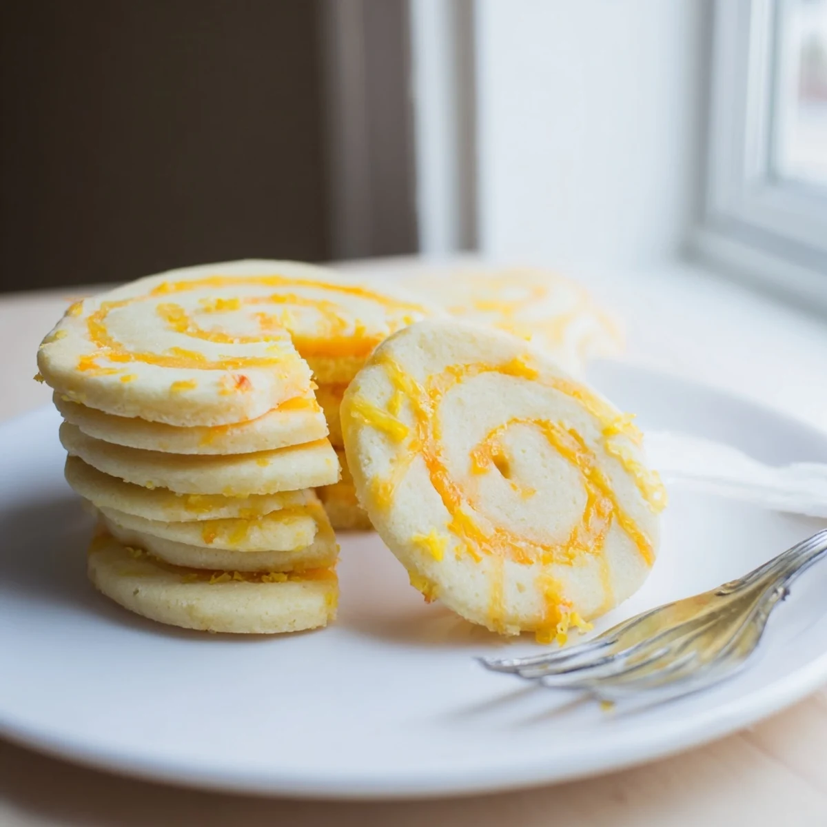 Soft baked sugar cookies topped with sweet pineapple and citrus zest in a bright orange and yellow swirl.  