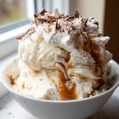 Homemade Snowy Day Caramel Frost in a glass, garnished with cinnamon and chocolate shavings.