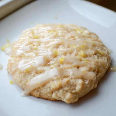 A close-up of Ricotta Honey Sugar Cookies showcasing a tender crumb and a delicate honey glaze drizzle.  