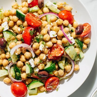 Mediterranean chickpea salad glistening with lemon olive oil dressing in a rustic serving bowl