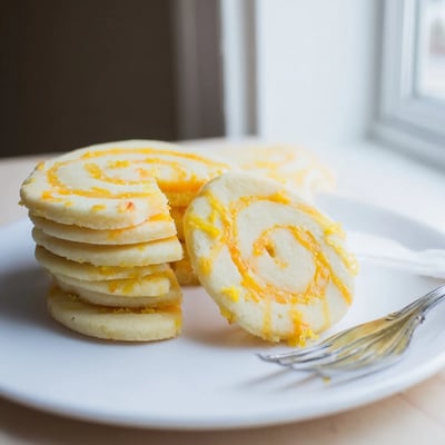 Soft baked sugar cookies topped with sweet pineapple and citrus zest in a bright orange and yellow swirl.  